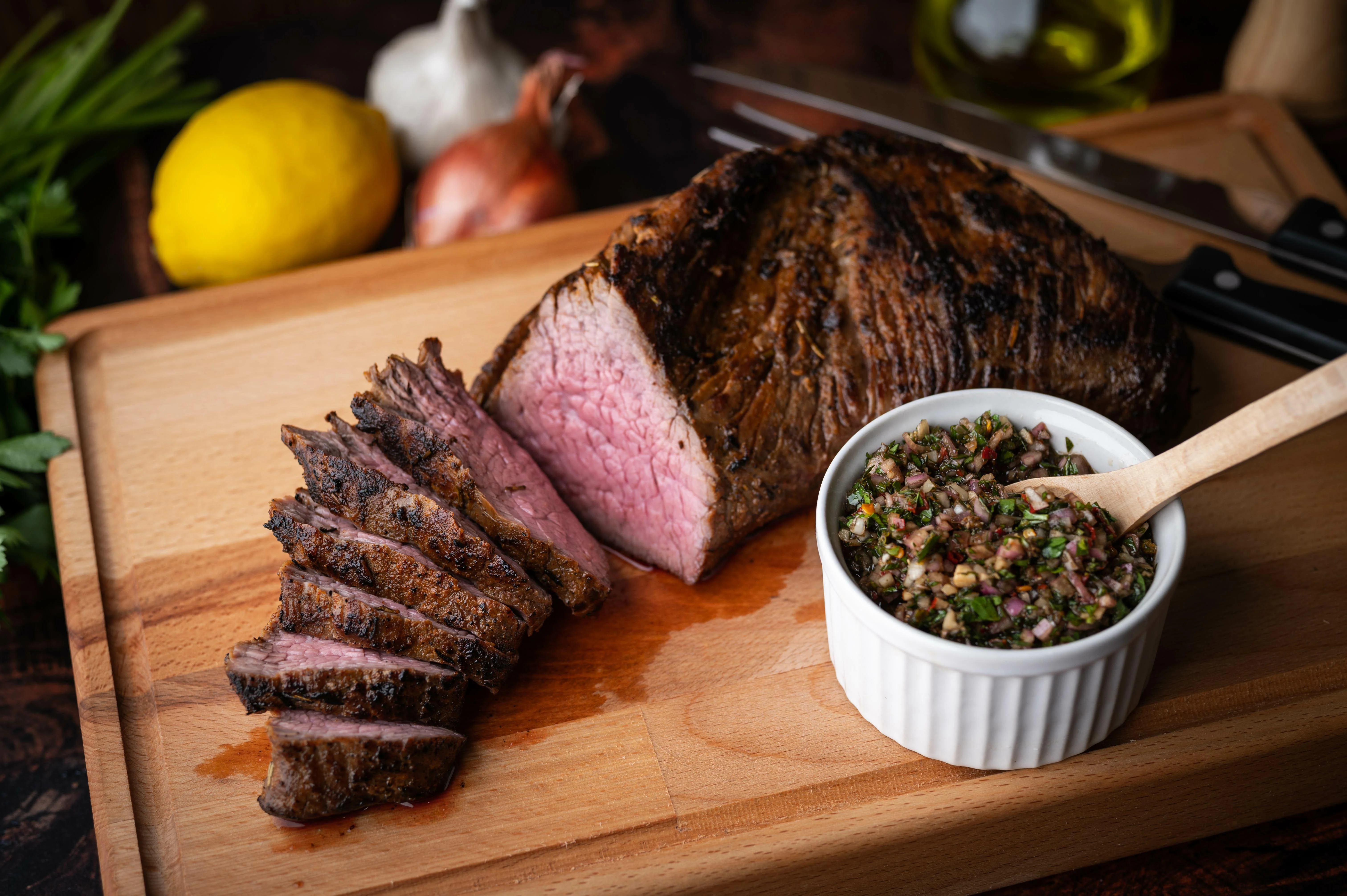 A tri-tip roast being seared in a very hot cast iron skillet with a dark golden crust forming on the surface