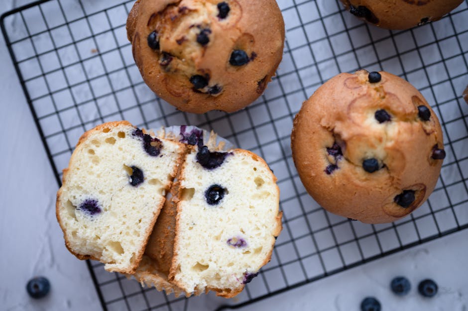 A batch of freshly baked gluten-free blueberry muffins on a cooling rack